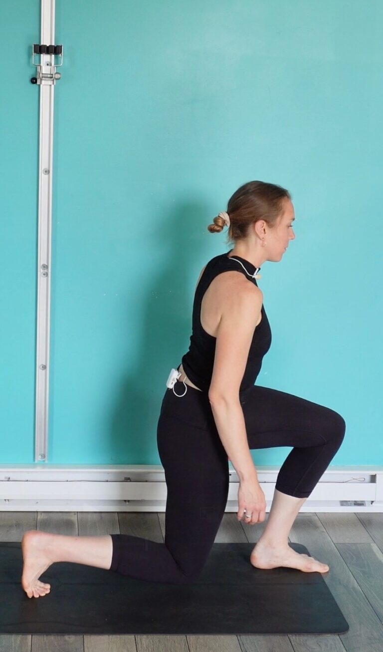 Dr. Chloe stepping forward on her left foot into a lunge position as the first part of this glute activation exercise